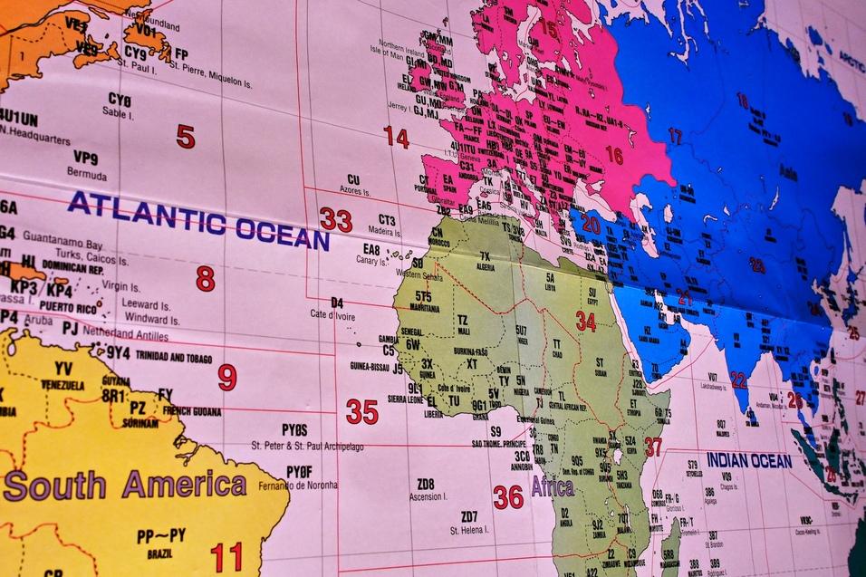 eine Amateurfunkkarte zeigt Nord und Südamerika, Europa, Afrika und Asien aus einer schrägen Perspektive, Die einzelnen Kontinente haben verschiedene Farben, es sind viele ITU-Landeskenner und Zonenmarkierungen zu sehen. eine Amateurfunkkarte zeigt Nord und Südamerika, Europa, Afrika und Asien aus einer schrägen Perspektive, Die einzelnen Kontinente haben verschiedene Farben, es sind viele ITU-Landeskenner und Zonenmarkierungen zu sehen.