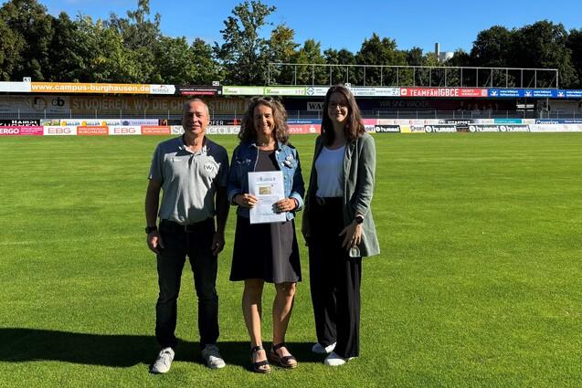 das Bild zeigt Gesch&auml;ftsf&uuml;hrer Heiko Hiller, Michaela Hausmann sowie Vereinsmanagerin Laura K&ouml;nig, bei der &Uuml;bergabe der goldenen Ehrenamtskarte f&uuml;r 25 Jahre ehrenamtliche T&auml;tigkeit